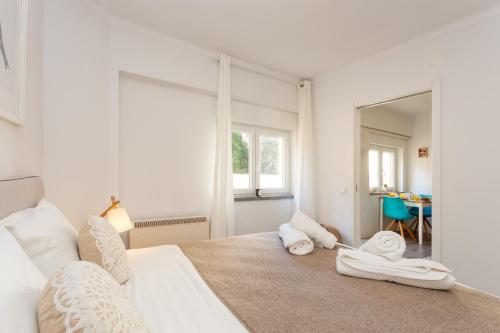エストリルにあるSeaside Serenity in Estorilの白いベッドルーム(大型ベッド、タオル付)