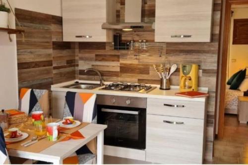 una cocina con fregadero y estufa horno superior en Little Home, en Bolsena