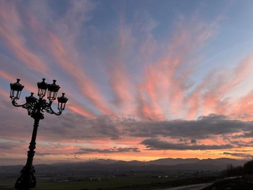 a street light with a sunset in the background at La Valle del Re - Agriturismo in Medesano
