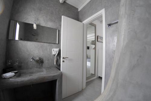 bagno con lavandino e specchio di Anemoi Resort a Naoussa