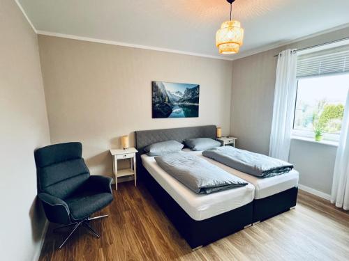 1 dormitorio con 1 cama y 1 silla en Ferienwohnungen Maedchen en Wunstorf
