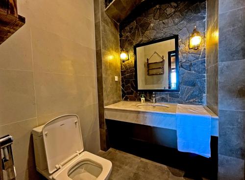 a bathroom with a toilet and a sink and a mirror at Cedar Lodges Resort and Residences Galiyat in Chhāngla Gali