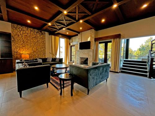 a living room with a couch and a fireplace at Cedar Lodges Resort and Residences Galiyat in Chhāngla Gali