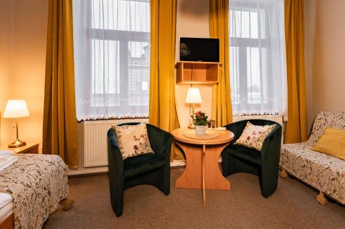 a hotel room with a bed and a table and chairs at Penzion Věžička in Lázně Bělohrad