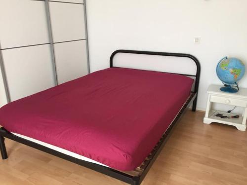 Una cama en una habitación con una manta roja. en Maison proche de plage, 3 chambres en La Rochelle