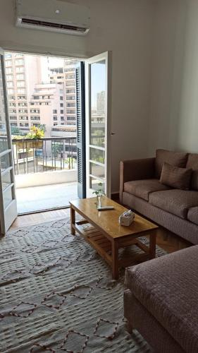 a living room with a couch and a coffee table at Dokki I Madina Apt I 2min to Nile in Cairo