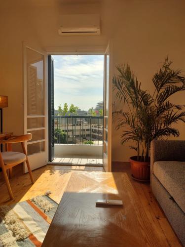 a living room with a couch and a large window at Dokki I Madina Apt I 2min to Nile in Cairo