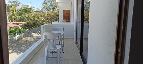 balkon z białymi krzesłami i widokiem na patio w obiekcie Departamento Marsopas a 5 minutos a pie de Bahía Carrizalillo!!! 5 w mieście Puerto Escondido