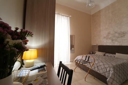 a bedroom with a bed and a desk and a table with a lamp at CASA FELICE Suite Room in Taranto