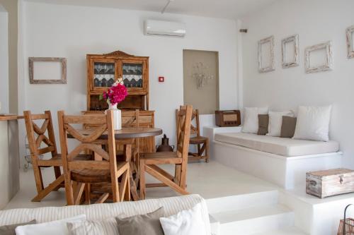 een woonkamer met een tafel en stoelen en een bank bij Anemoi Resort in Naousa