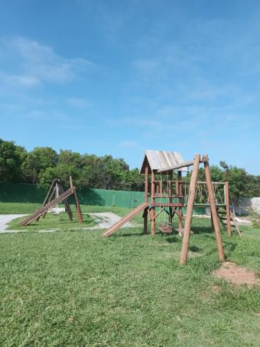 un gruppo di attrezzature da gioco in legno nell'erba di Casa Espetacular em Buzios casabardotbuzios a Búzios