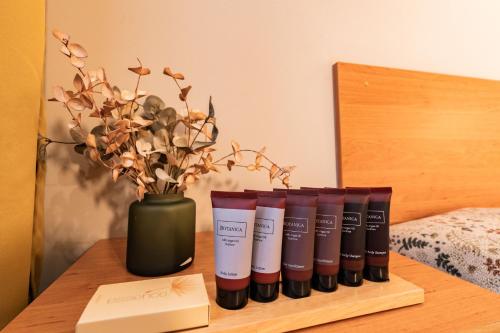 a row of products on a wooden table with a vase at Penzion Věžička in Lázně Bělohrad
