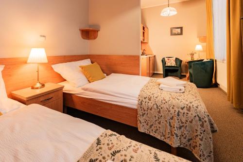 a hotel room with two beds and a lamp at Penzion Věžička in Lázně Bělohrad
