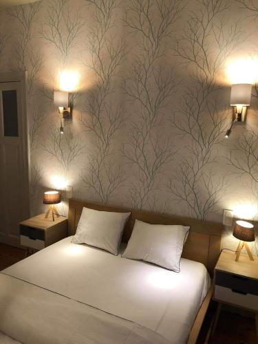a bedroom with a white bed with a wall mural at La couque cuivrée in Dinant