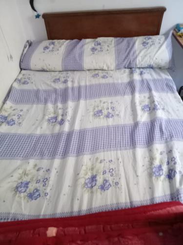 Una cama con un edredón azul y blanco. en Weza, 