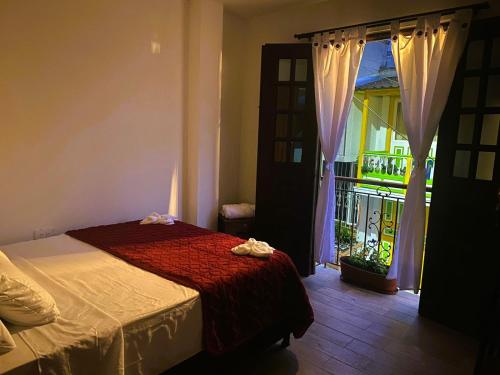 a bedroom with a bed and a door with a balcony at Hotel Casa Helena in Filandia