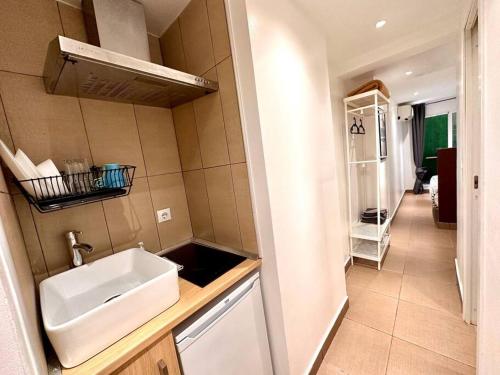 eine kleine Küche mit einem Waschbecken und einem Spiegel in der Unterkunft T6 Apartamento con terraza y sol! A 1`del metro in Barcelona