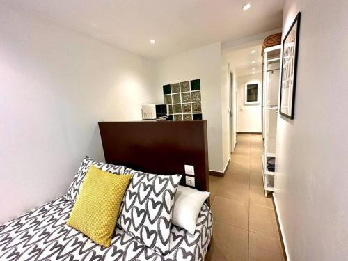 ein Schlafzimmer mit einem Bett mit einem gelben und weißen Kissen in der Unterkunft T6 Apartamento con terraza y sol! A 1`del metro in Barcelona