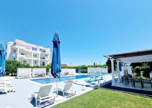- une piscine avec des chaises et des parasols à côté d'un bâtiment dans l'établissement Le Domaine Green Paradise, à Ulcinj