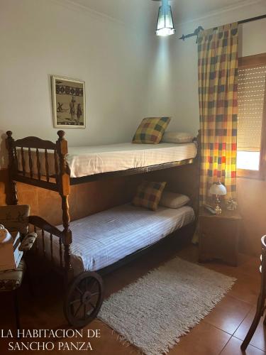 a bedroom with two bunk beds and a rug at Casa de la Mancha in Mota del Cuervo