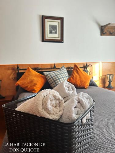 a basket filled with towels sitting on a bed at Casa rural compartida Casa de la Mancha in Mota del Cuervo