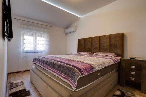 a bedroom with a large bed and a window at DiVino Apartment in Tivat