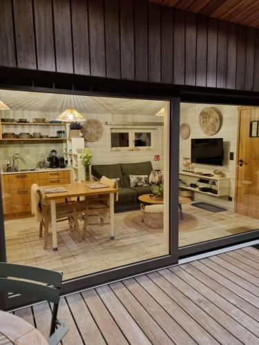 a dining room and living room with sliding glass doors at LAC ABANE AU LAC in Butgenbach
