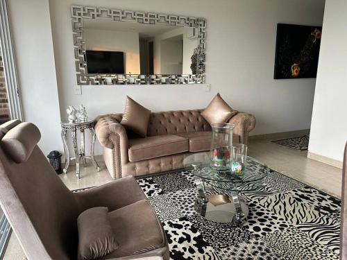 uma sala de estar com um sofá e um espelho em Cozy Oasis with Panoramic Views em Cerritos