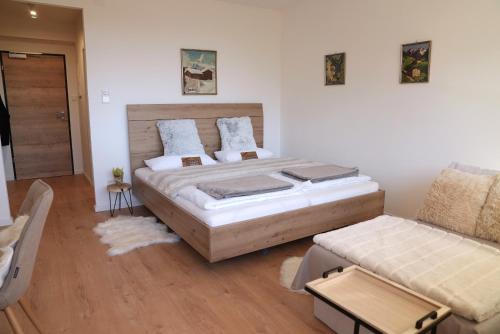 a bedroom with a large bed and a couch at Bergblick 411 am Wolfgangsee in Strobl