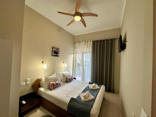 a bedroom with a bed with a ceiling fan at BO Home in Souda