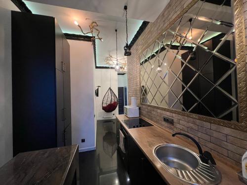 a bathroom with a sink and a mirror at Center Apartment in Chişinău