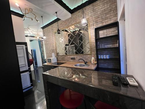 a bathroom with a sink and a brick wall at Center Apartment in Chişinău