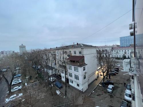 a white building with a red roof next to a parking lot at Center Apartment in Chişinău
