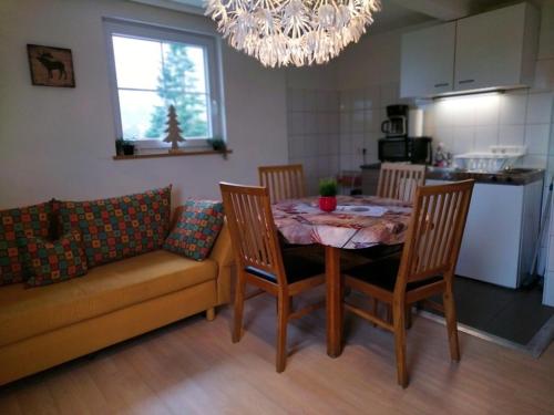 a kitchen with a table and chairs and a chandelier at Ferienwohnung Waldrausch in Baiersbronn