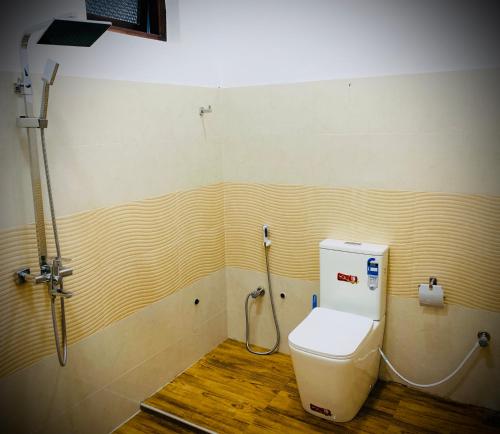 a bathroom with a toilet with a hose at Villa Exora Pasikudha in Batticaloa