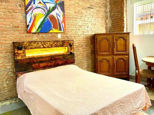 ein Schlafzimmer mit einem Bett und einem Wandgemälde in der Unterkunft L1 Estudio nuevo! Al lado del metro en Sants in Barcelona