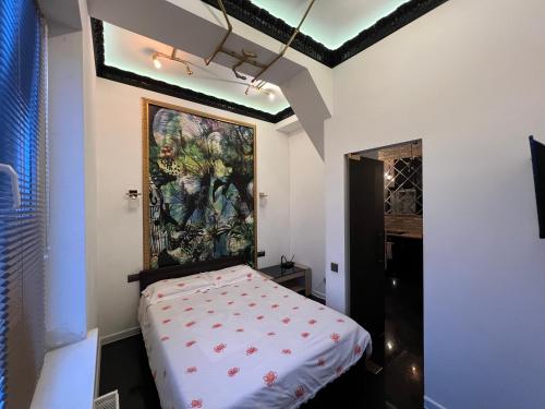 a room with a bed with a painting on the wall at Center Apartment in Chişinău