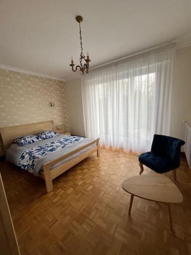 a bedroom with a bed and a chair at maison bretonne 7 personnes in Mellac