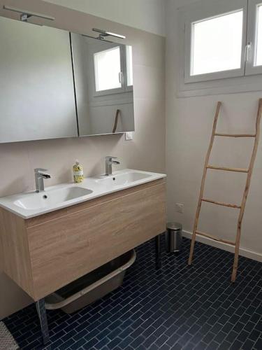 a bathroom with a sink and a mirror at maison bretonne 7 personnes in Mellac