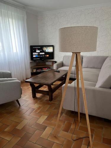 a living room with a couch and a table with a lamp at maison bretonne 7 personnes in Mellac