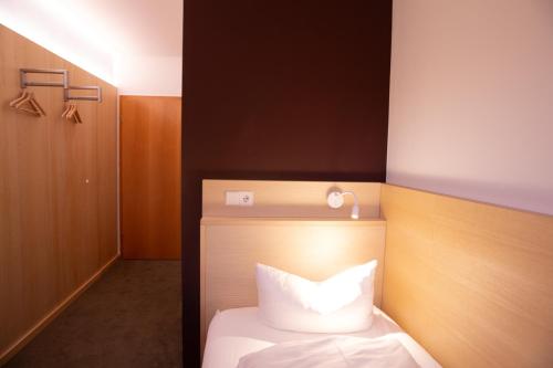 a bedroom with a bed with a white pillow at Hotel de Saxe Leipzig in Leipzig