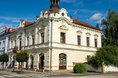a white building with a tower on top of it at Penzion Věžička in Lázně Bělohrad