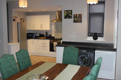 een keuken met een tafel en stoelen en een wasmachine bij Ashville Grange in Scarborough