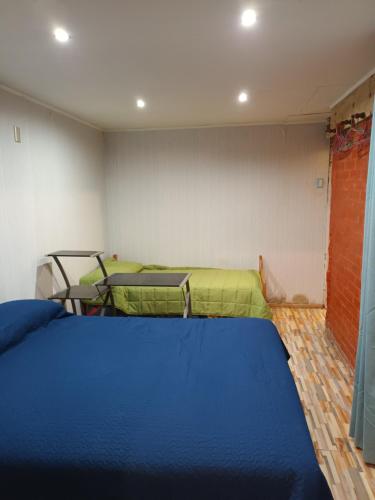 1 dormitorio con cama azul y sábanas verdes en Exelente casa completamente equipada., en Quintero