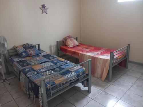 een kamer met 2 bedden en een tafel en een bed bij Bel'lune in La Trinité