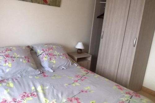 a bedroom with a bed with pink flowers on it at La route bleue in Ploumilliau