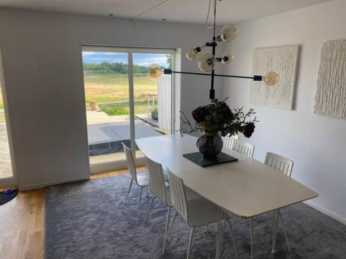 uma sala de jantar com uma mesa branca e cadeiras em Vackert boende med utsikt över fantastisk golfbana em Brokind