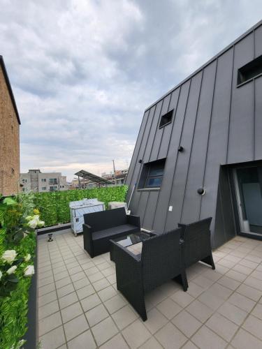 - une terrasse avec 2 chaises et une table dans un bâtiment dans l'établissement Casamigalu, à Séoul