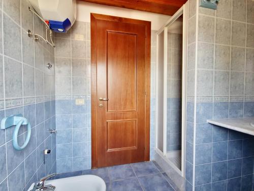 baño con aseo y puerta de madera en Casa Mara, en Cala Liberotto