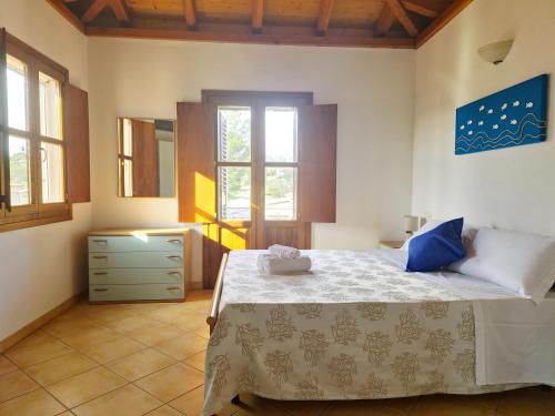 1 dormitorio con 1 cama, vestidor y ventanas en Casa Mara, en Cala Liberotto